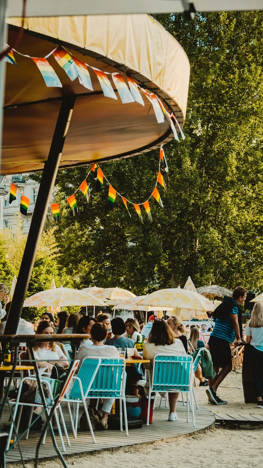 Gastgarten mit bunten Wimpeln und Sonnenschirmen im Sommer