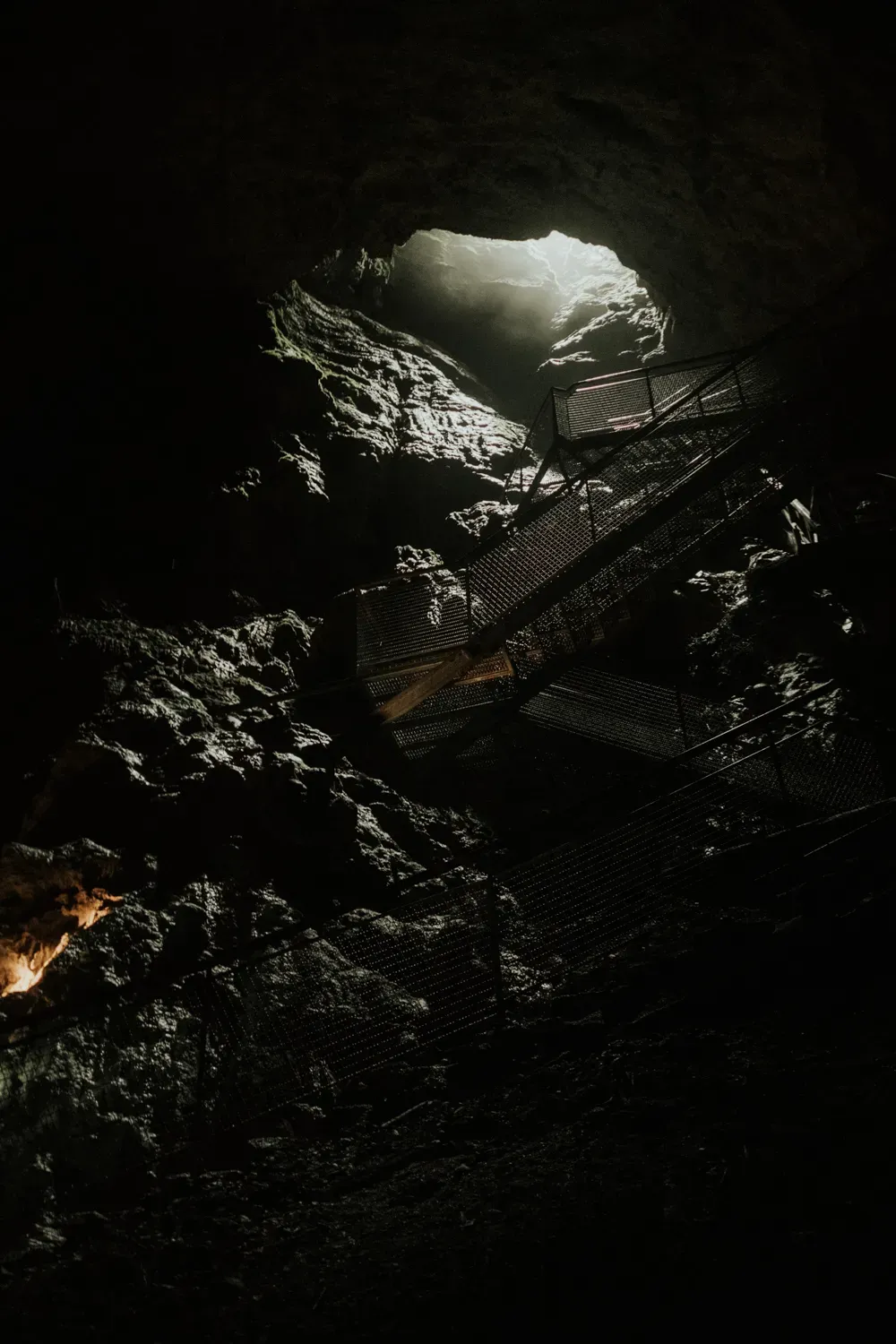 Blick aus einer dunklen Höhle hinauf zum Tageslicht