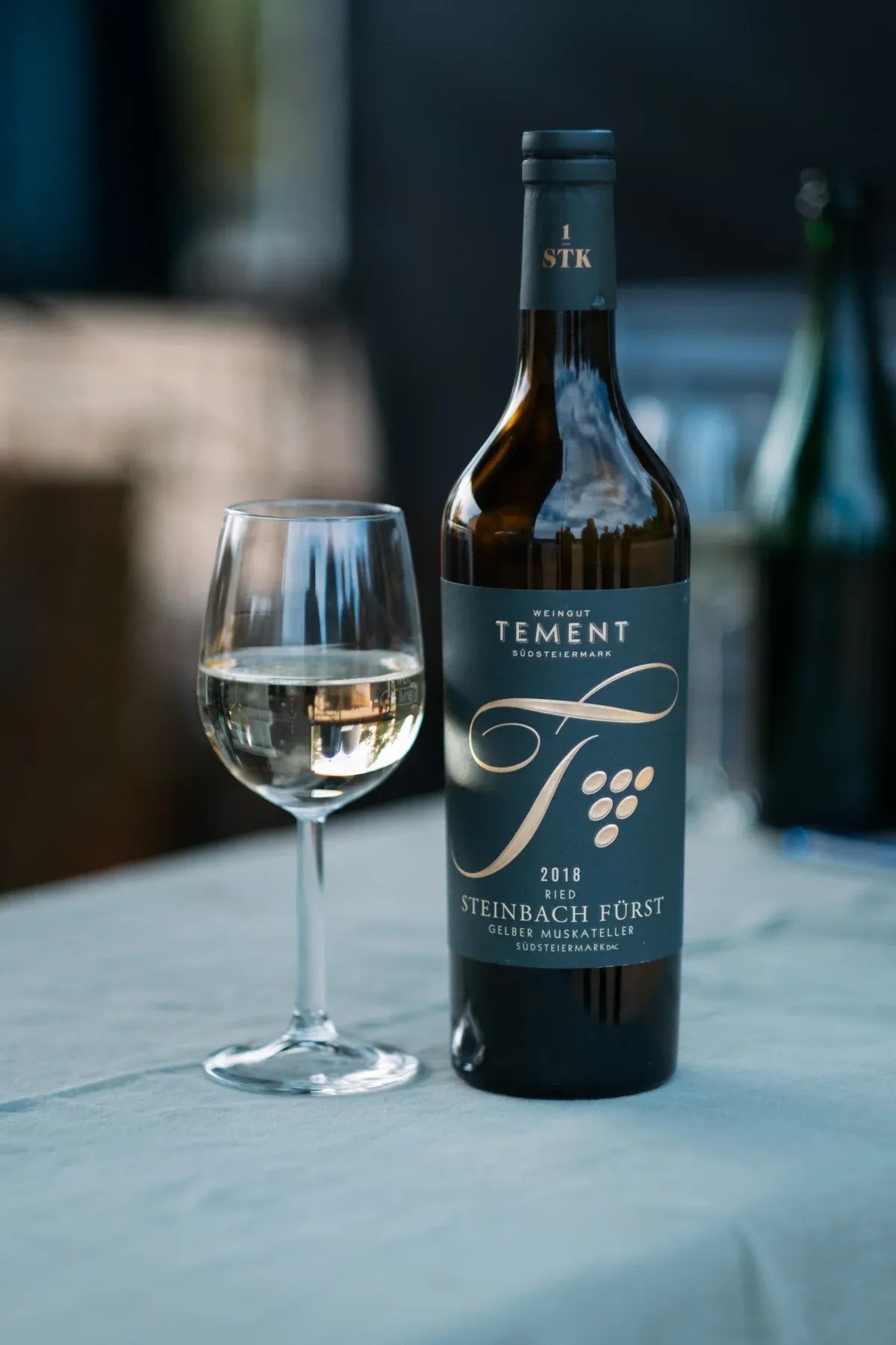 Flasche Weißwein mit gefülltem Glas auf gedecktem Tisch