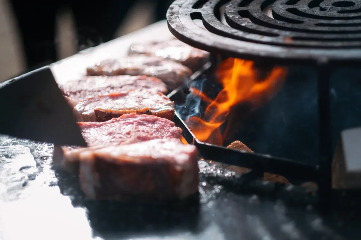 Steaks auf der Feuerplatte mit offener Flamme