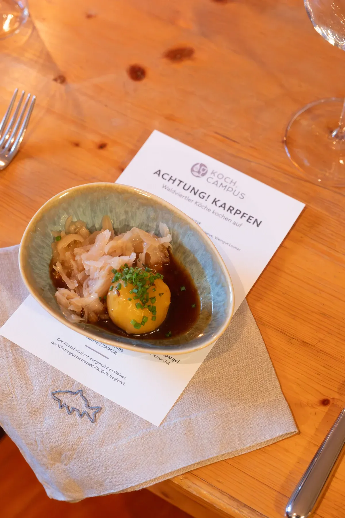 Karpfengericht in Keramikschale auf der Menükarte eines Karpfen-Dinners