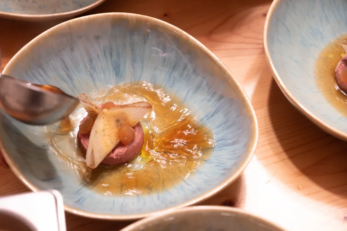 Sauce wird über ein Gericht in blauer Keramikschale gelöffelt