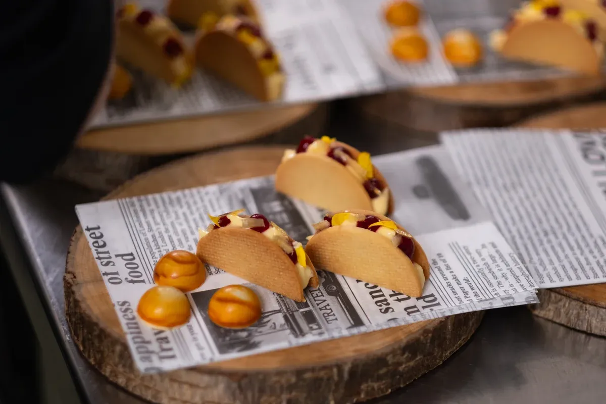 Mini-Tacos auf Zeitungspapier und Holzscheibe angerichtet