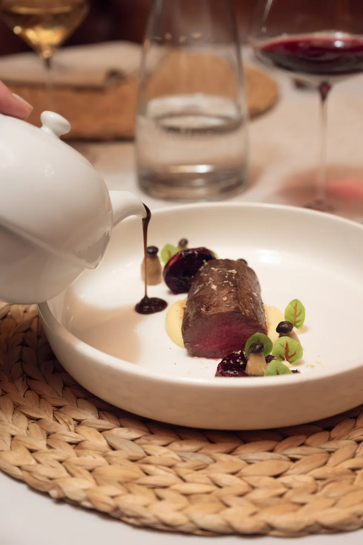 Sauce wird über ein Fleischgericht gegossen