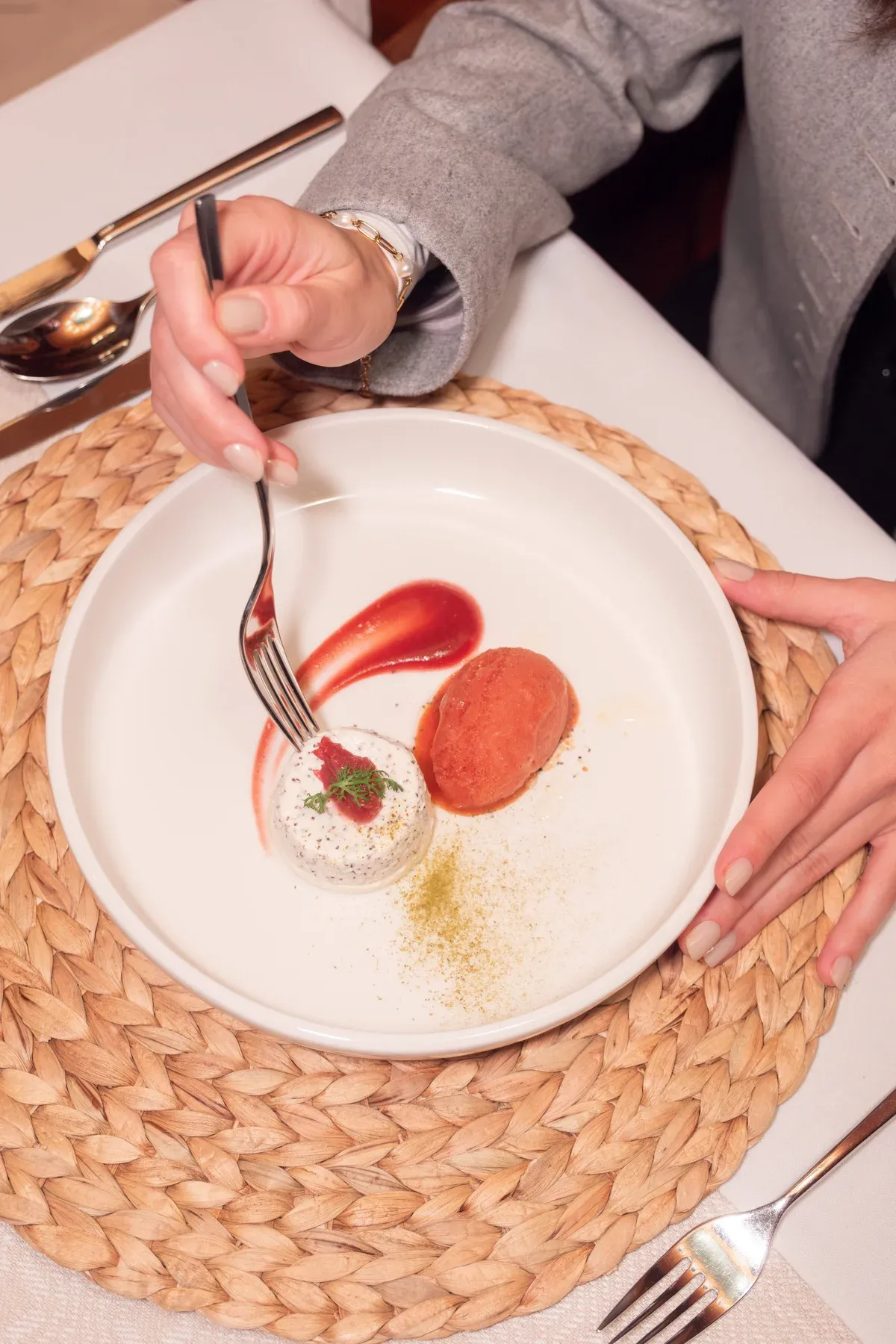 Gast isst Dessert mit roter Sauce, Blick von oben